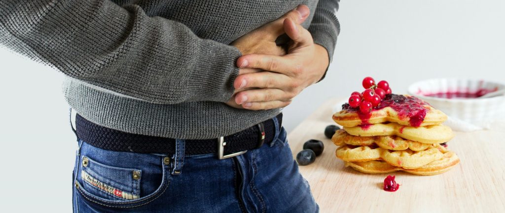 the torso of a man holding his stomach