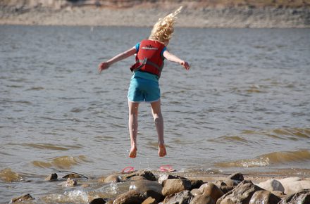 child jumping near water