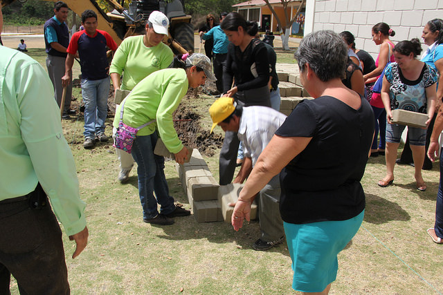 The parents of children in Gary Young's Chongon, Ecuador, school lay the first bricks for the expansion of the school to include high school students.