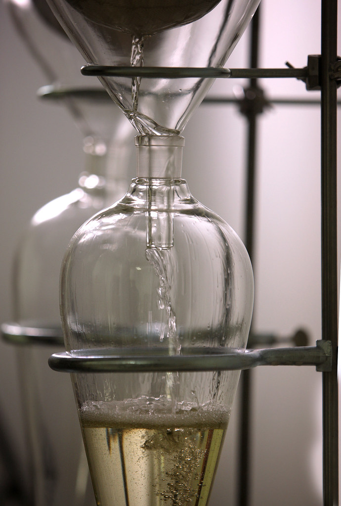 a pure therapeutic grade essential oil being distilled into a clear glass vial