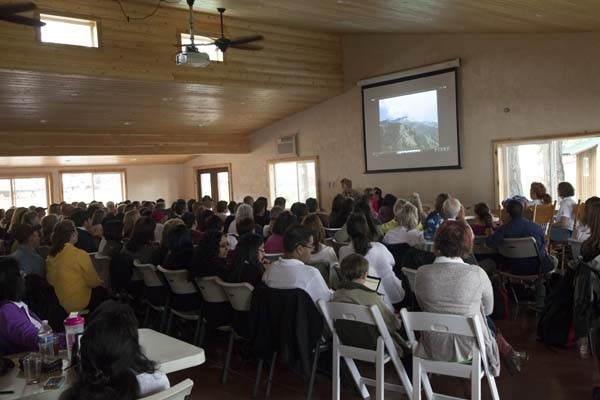 a group of about 40 people, seated, listening to a presentation